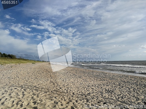 Image of Wild sandy beach under cloudy sky of sunset