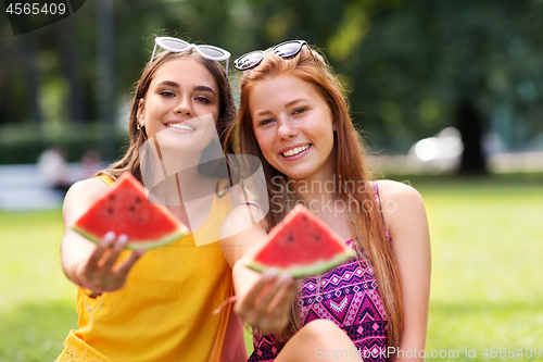 Image of teenage girls eating watermelon at picnic in park