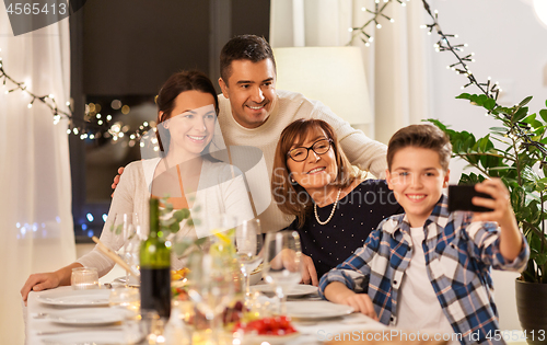 Image of family having dinner party and taking selfie