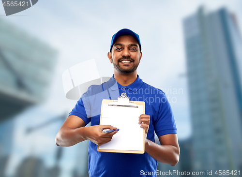 Image of happy indian delivery man with clipboard in blue