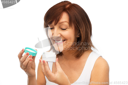 Image of smiling senior woman with cream jar