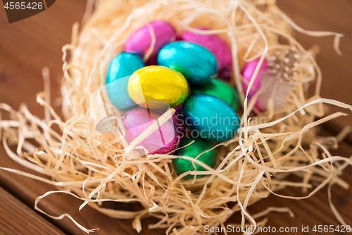 Image of chocolate easter eggs in straw nest on table