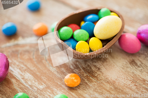 Image of chocolate easter egg and candy drops on table