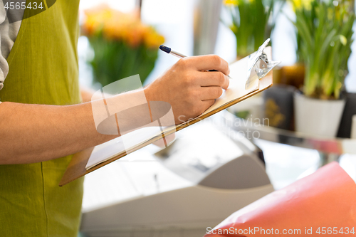 Image of florist man with clipboard at flower shop