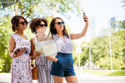 Image of women with city guide and map taking selfie
