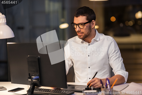 Image of designer with computer and pen tablet at office