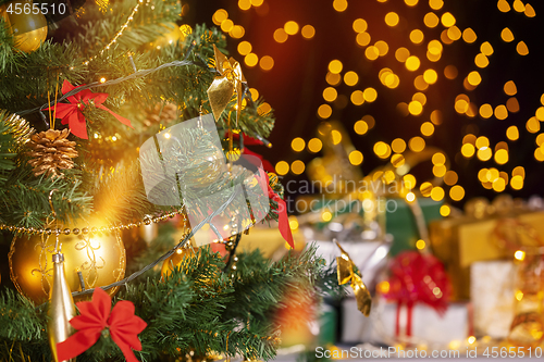 Image of Christmas presents and candles under Christmas tree