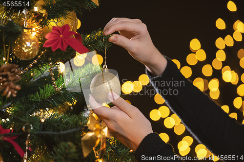 Image of Girl decorates a Christmas tree