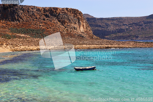 Image of Sea view with clear turquoise water and empty boat, Crete island