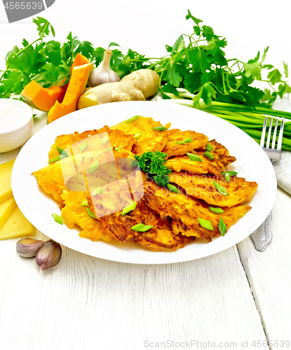 Image of Pancakes of pumpkin with cheese in white plate on wooden board