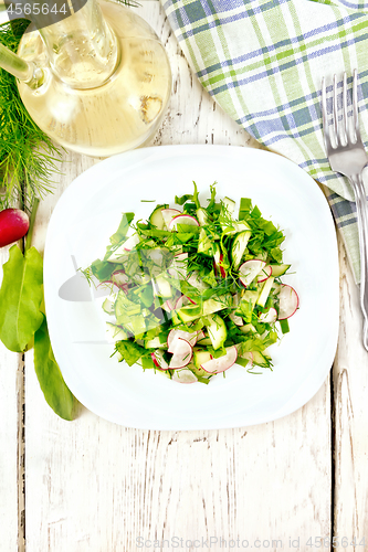 Image of Salad of radish and sorrel with oil in plate on board top