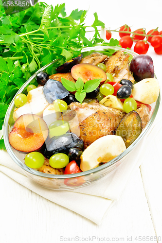 Image of Chicken with fruits and tomatoes in pan on light board