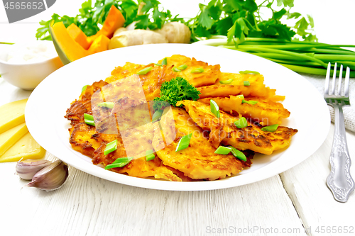 Image of Pancakes of pumpkin with cheese in white plate on board