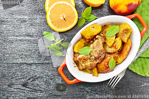 Image of Turkey with peaches in pan on dark board top