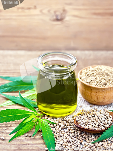 Image of Oil hemp in jar with flour in bowl on old board