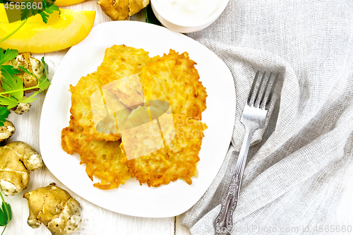 Image of Pancakes of pumpkin with Jerusalem artichoke on light board top