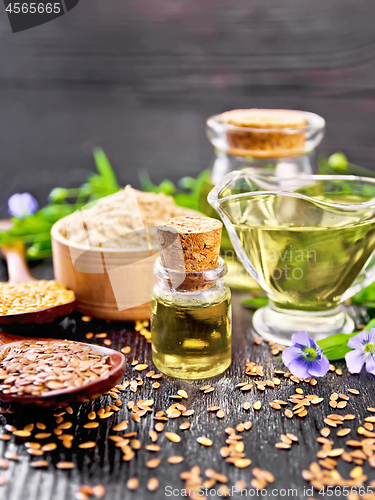 Image of Oil flaxseed with flour and seeds on dark wooden board