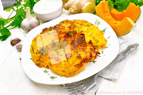 Image of Pancakes of pumpkin in plate on light wooden board