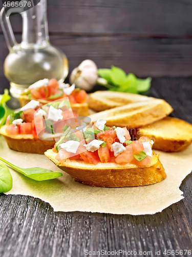 Image of Bruschetta with tomato and cheese on parchment