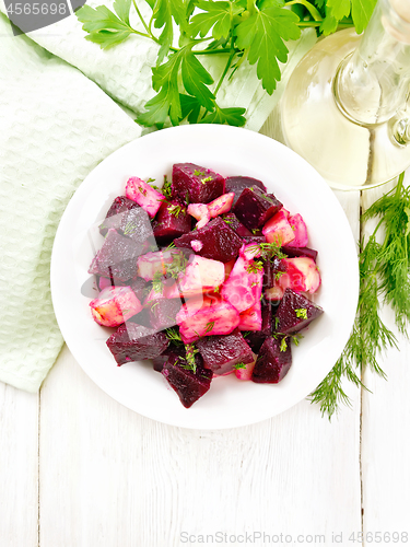 Image of Salad of beets and potatoes in plate on board top