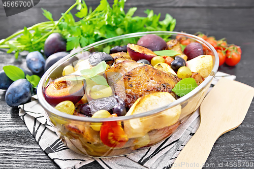 Image of Chicken with fruits and tomatoes in glass pan on board