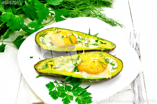 Image of Scrambled eggs in avocado on wooden board