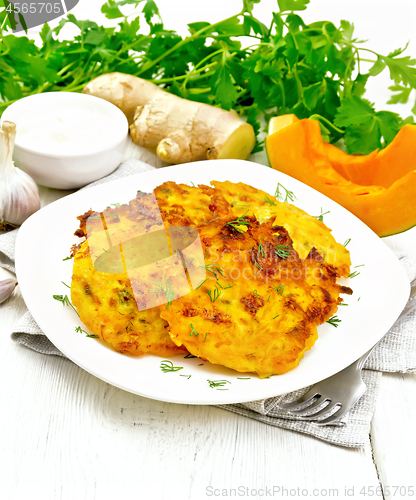 Image of Pancakes of pumpkin in plate on board