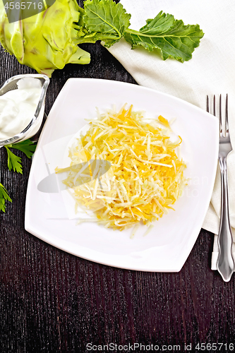 Image of Salad of carrot and kohlrabi in plate on dark board top