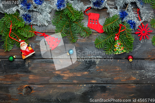 Image of Festive Christmas composition with tinsel and fir branches.