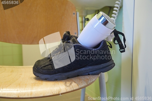 Image of Drying shoes with a hairdryer