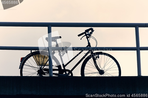 Image of Bicycle on a street silhouette against dusk sky