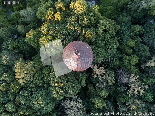 Image of Top view of a round old roof with people around green trees. Aerial view from the drone