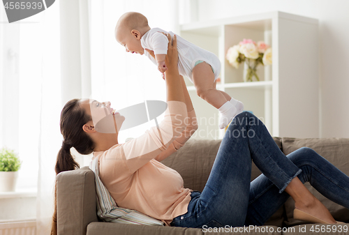 Image of happy mother playing with little baby boy at home