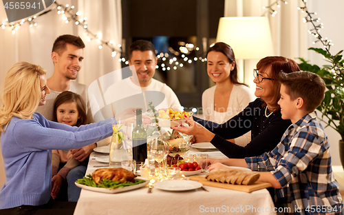 Image of happy family having dinner party at home