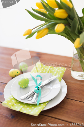 Image of easter egg, plates, cutlery and tulip flowers