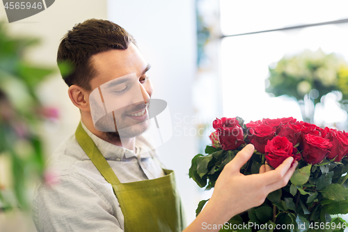 Image of florist or seller setting red roses at flower shop