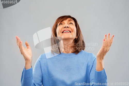 Image of happy senior woman looking up