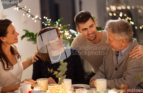 Image of happy family having tea party at home