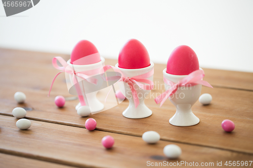 Image of easter eggs in holders and candy drops on table
