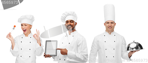Image of chefs with tablet computer, cloche and tomato