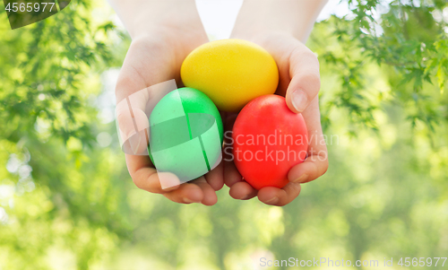 Image of close up of girl with bowl of colored easter eggs