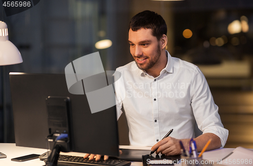 Image of designer with computer and pen tablet at office