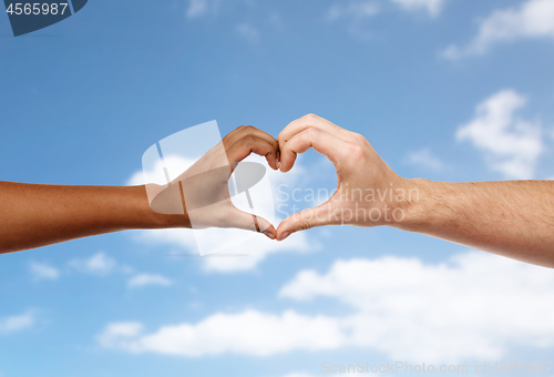 Image of hands of different skin color making heart shape