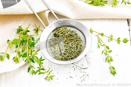 Image of Thyme fresh and dry in strainer on table