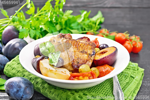 Image of Chicken with fruits and tomatoes in plate on board