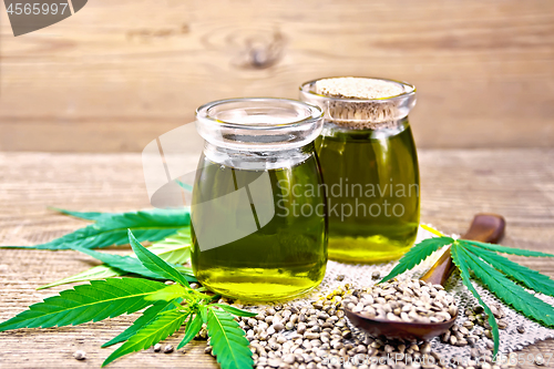 Image of Oil hemp in two jars and spoon on board