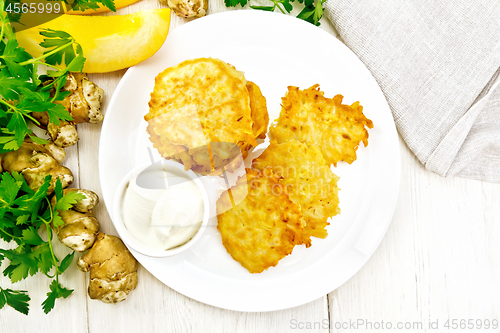 Image of Pancakes of pumpkin with Jerusalem artichoke on white board top