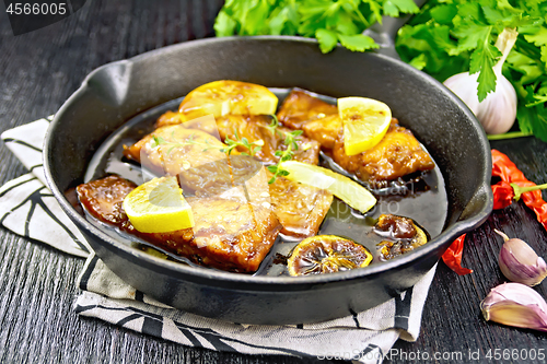 Image of Salmon with sauce in pan on board