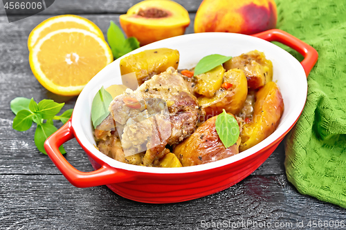 Image of Turkey with peaches in pan on black board