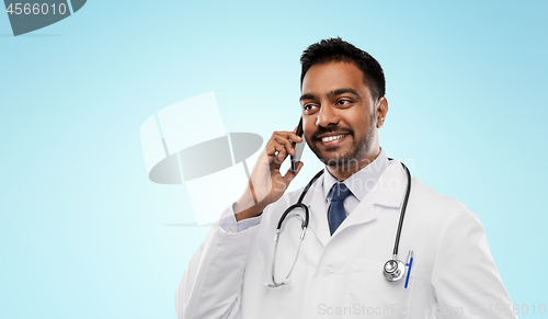 Image of smiling indian male doctor calling on smartphone